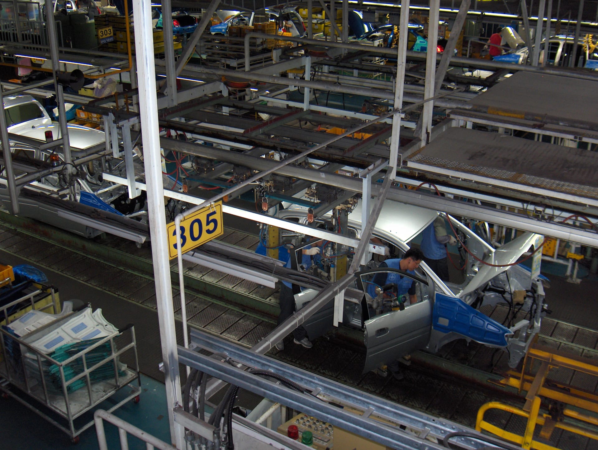 Assembly line at Hyundai's car factory in Ulsan, South Korea, with car bodies suspended above the conveyor